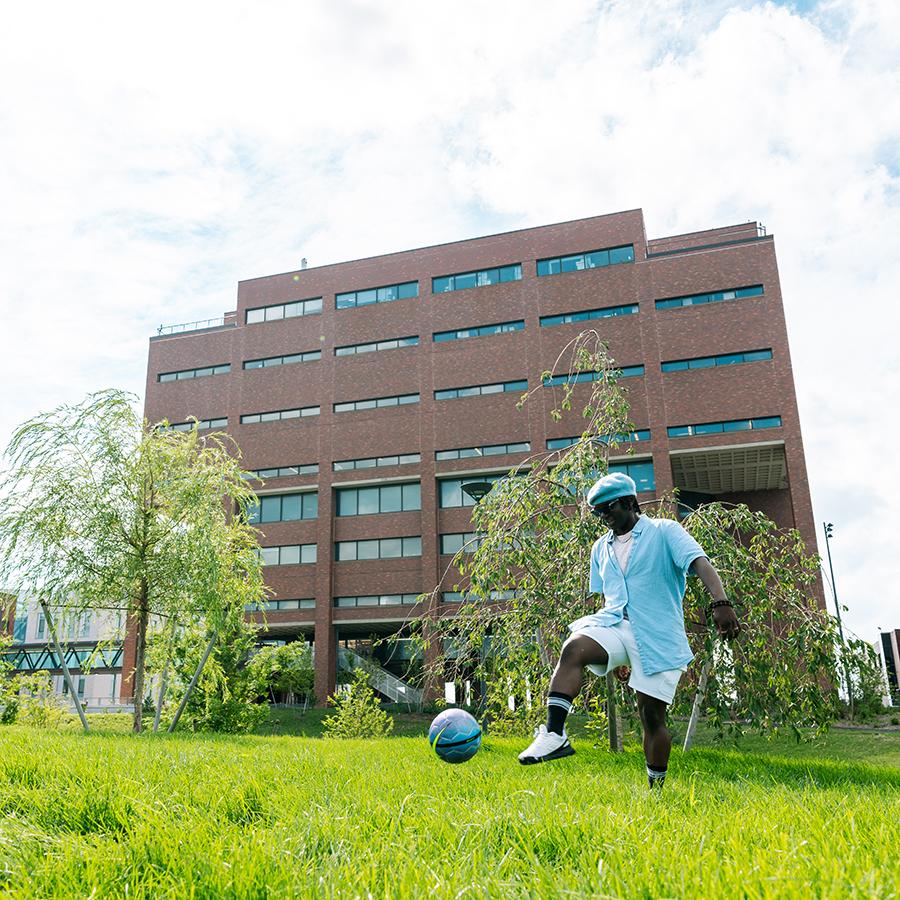 quad student plays with ball on campus green quad