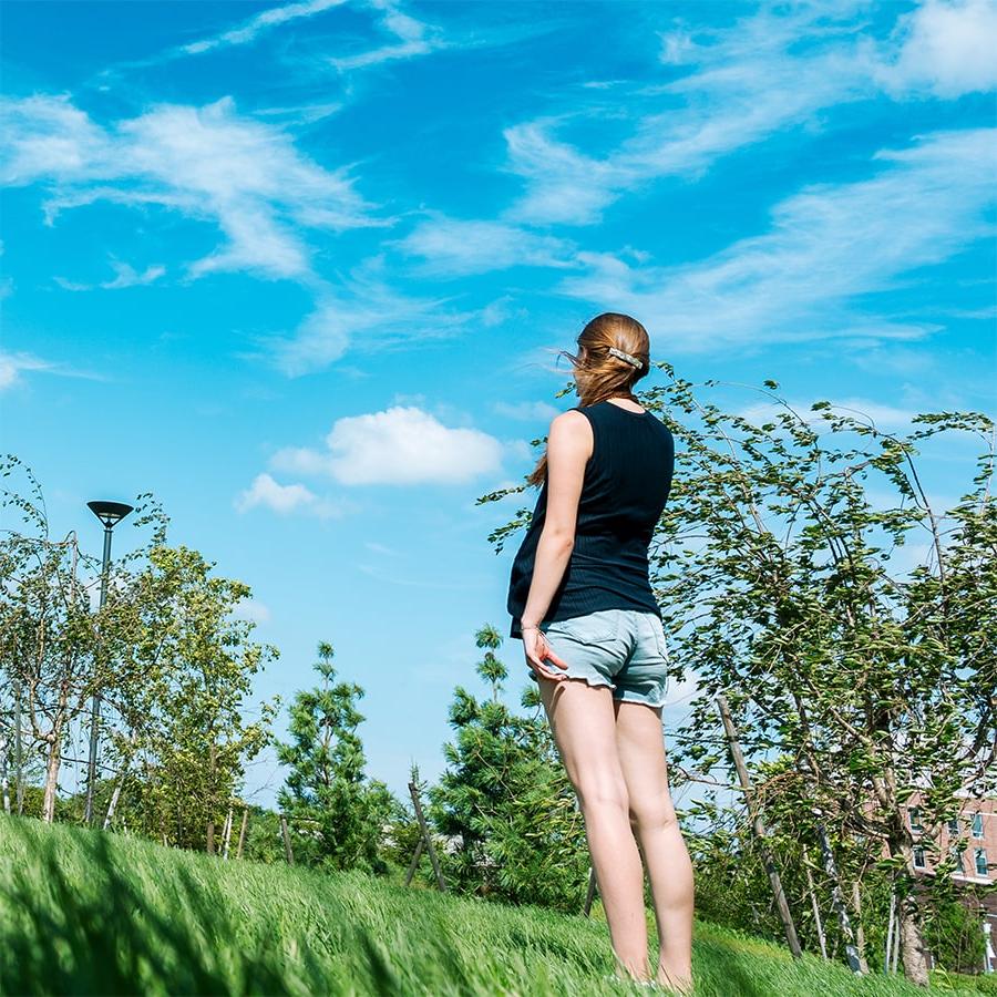 student in field of grass in quad